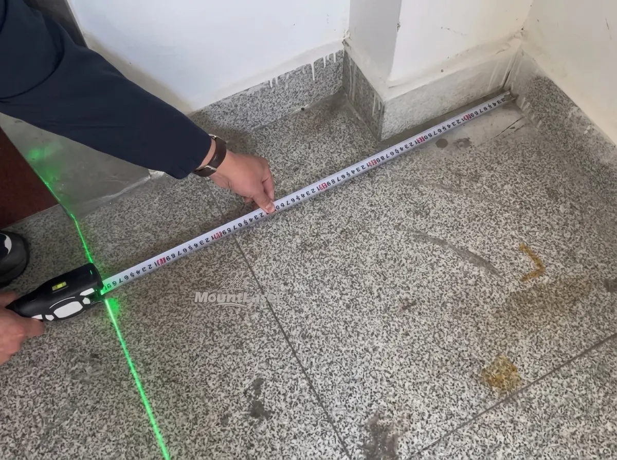 Mountlaser LTM01 laser tape measure extending into a corner with green laser guide